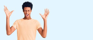 Sıradan kıyafetler giyen genç Afro-Amerikalı adam başarı için deli ve çılgınlığı kutluyor kollarını kaldırmış ve gözlerini kapatmış heyecanla bağırıyor. Kazanan konsept 