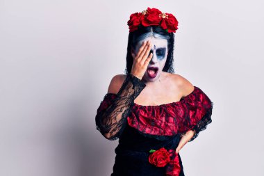 Meksika 'da ölü makyajı yapan genç bir kadın yarı yüzünü, gözünü ve ağzını elleriyle kapatmaktan yorulmuş. Yüzüm acıyor.. 