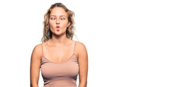 Güzel beyaz kadın günlük kıyafetler giyip dudaklarıyla balık suratı yapıyor. Çılgınca ve komik bir jest. Komik ifade. 