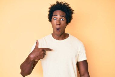 Yakışıklı afro saçlı, parmaklarıyla kendini gösteren afro-amerikalı adam. Korkmuş ve şok olmuş bir şekilde şaşkınlık, şaşkınlık ifadesi, korku ve heyecan dolu bir yüz.. 