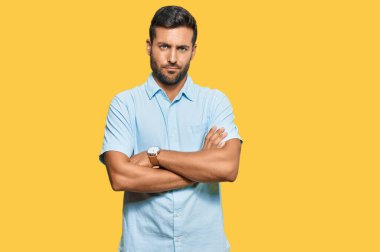Gündelik kıyafetler giyen yakışıklı İspanyol adam şüpheci ve gergin, yüzünde çapraz kollu tasvip etmeyen ifade. negatif kişi. 