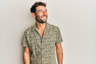 Sakallı, sıradan moda gömleği giyen, rahat bir görünüm takınan, kendine güveni olan yakışıklı bir adam.. 