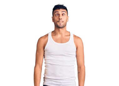 Gündelik kıyafetler giyen genç İspanyol adam dudaklarıyla balık suratı yapıyor, çılgınca ve komik bir jest. Komik ifade. 