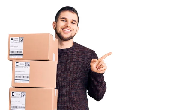 Jovem Homem Bonito Segurando Pacote Entrega Sorrindo Feliz Apontando Com — Fotografia de Stock