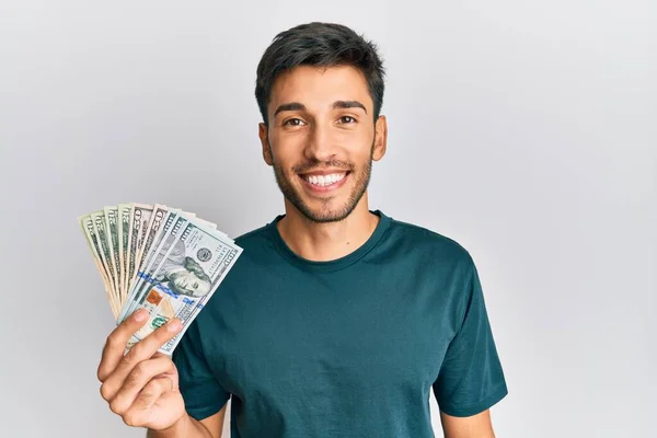 Joven Hombre Guapo Sosteniendo Dólares Buscando Positivo Feliz Pie Sonriendo — Foto de Stock