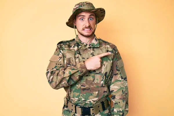 Young Caucasian Man Wearing Camouflage Army Uniform Pointing Aside Worried — Stock Photo, Image