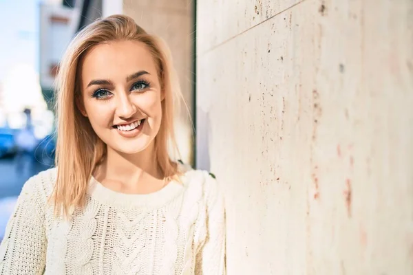 Genç Sarışın Kız Mutlu Bir Şekilde Gülümsüyor Şehrin Duvarına Yaslanıyor — Stok fotoğraf