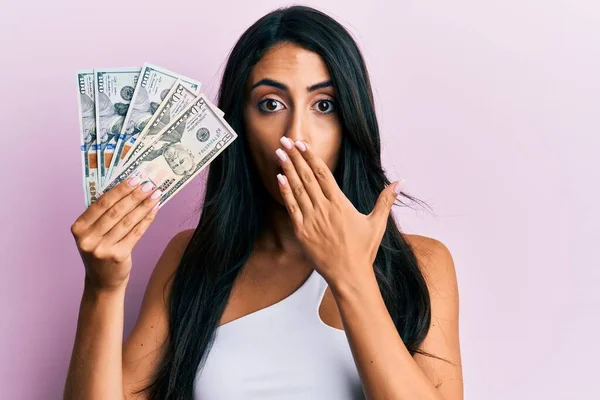 Beautiful Hispanic Woman Holding Dollars Covering Mouth Hand Shocked Afraid — Stock Photo, Image