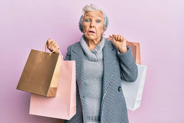 Senior Gråhårig Kvinna Som Håller Shoppingpåsar Ledtrådar Och Förvirrade Uttryck — Stockfoto