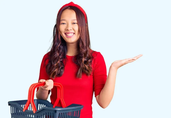 Mladý Krásný Číňan Dívka Drží Supermarket Nákupní Košík Slaví Vítězství — Stock fotografie