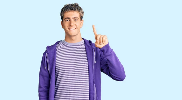 年轻英俊的男子穿着休闲的紫色运动衫 带着第一指尖 面带微笑 自信而快乐 — 图库照片