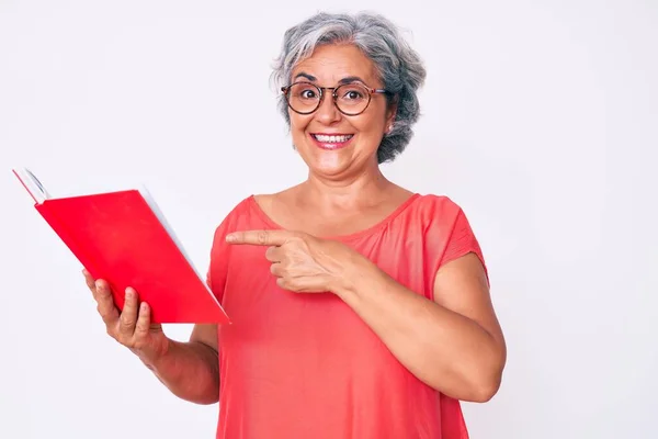 Mulher Hispânica Sênior Usando Óculos Segurando Livro Sorrindo Feliz Apontando — Fotografia de Stock