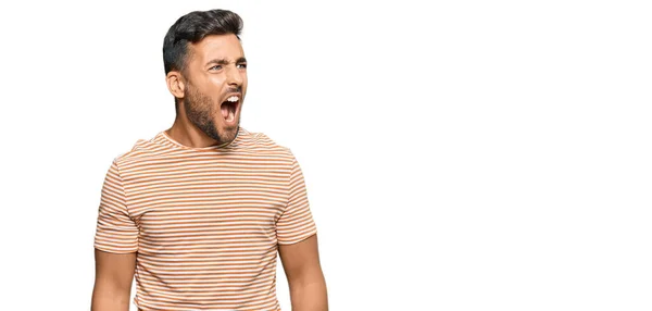 カジュアルな服を着たハンサムなヒスパニック系の男性は怒って怒りと怒りを叫び 怒りで叫んで怒っている 怒りと攻撃的な考え方 — ストック写真