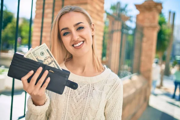 Jovem Loira Sorrindo Feliz Segurando Carteira Com Dólares Cidade — Fotografia de Stock