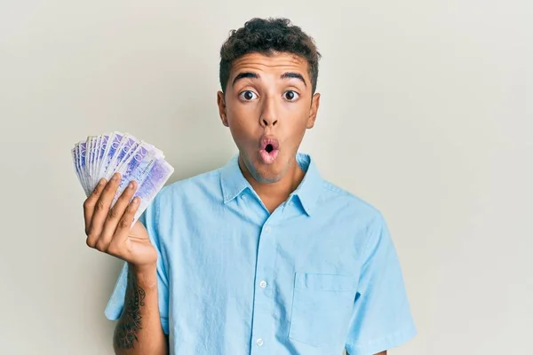 Joven Hombre Afroamericano Guapo Sosteniendo Billetes Coronas Suecas Asustado Sorprendido —  Fotos de Stock