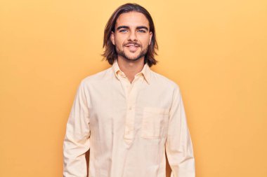 Yüzünde mutlu ve havalı bir gülümseme olan iş kıyafetleri giyen genç yakışıklı bir adam. şanslı kişi. 