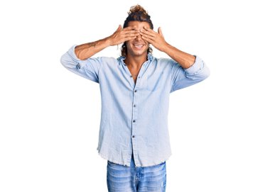 İspanyol asıllı genç adam yaz tarzı giyinmiş. Gözleri kapamış. Gülümseyen neşeli ve komik eller. kör kavram. 