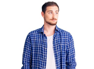 Genç, yakışıklı, beyaz, günlük kıyafetler giyen, gülümseyen, yan bakan ve düşünen bir adam.. 