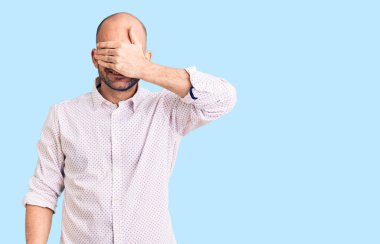 Zarif bir gömlek giyen yakışıklı bir adam. Gülümsüyor ve gülümsüyor. Gözleri şaşkınlıkla örtüyor. kör kavram. 