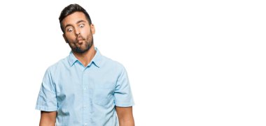 Yakışıklı, günlük kıyafetler giyen, dudaklarıyla balık suratı yapan, çılgın ve komik bir jest yapan bir İspanyol. Komik ifade. 