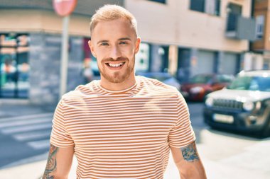 Genç İrlandalı adam gülümsüyor. Şehrin caddesinde mutlu bir şekilde yürüyor..