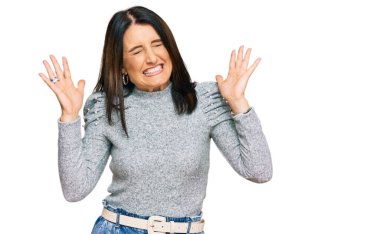 Orta yaşlı esmer kadın, gündelik giysiler giyip başarının çılgınlığını kutluyor. Kolları havada, gözleri kapalı, heyecanla bağırıyor. Kazanan konsept 