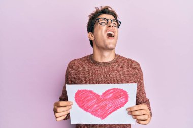 Kalbi tutan yakışıklı beyaz adam kızgın ve kızgın çığlıklar atıyor öfkeyle bağırıyor, öfkeyle yukarı bakıyor. 