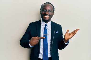 Yakışıklı, takım elbiseli ve kravatlı genç bir adam kameraya hayret ediyor ve gülümsüyor.. 