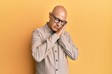 Orta yaşlı kel bir adam günlük kıyafetler ve gözlükler takmış uyur, yorgun düşler kurar ve elleriyle poz verir, gözleri kapalı gülümserdi.. 