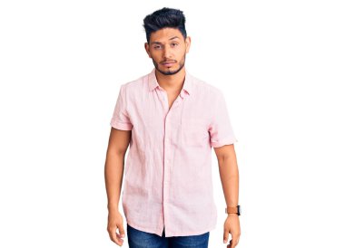 Yakışıklı Latin Amerikalı genç adam rahat bir yaz gömleği giyiyor uykulu ve yorgun görünüyor, yorgunluktan yorgun ve akşamdan kalma, sabahları tembel gözler. 