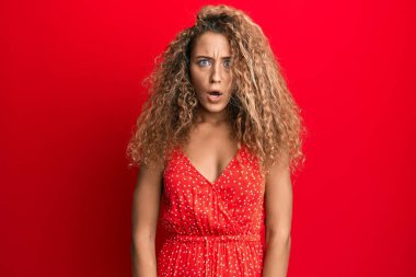 Yazlık elbise giyen güzel beyaz kız ağzı açık kalmış, korkmuş ve şaşırmış. 