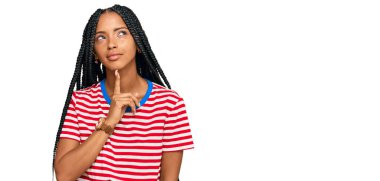 Güzel İspanyol kadın gündelik kıyafetler giyer şüphe üzerine yoğunlaşır çene üstüne parmak ve merak içinde yukarı bakar. 