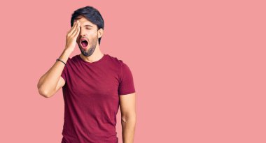 Yakışıklı, sıradan kıyafetler giyen, yarı yüzünü, göz ve ağzını eliyle kapayarak esnemekten yorgun düşmüş İspanyol bir adam. Yüzüm acıyor.. 