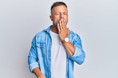 Sıradan bir kot ceket giyen yakışıklı kaslı adam ağzıyla ağzını kapatmaktan sıkılmış. Huzursuz ve uykulu.. 