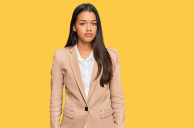 İş ceketi giyen güzel İspanyol kadın yüzünde ciddi bir ifadeyle rahatlamış. Basit ve doğal bir şekilde kameraya bakıyorsun.. 