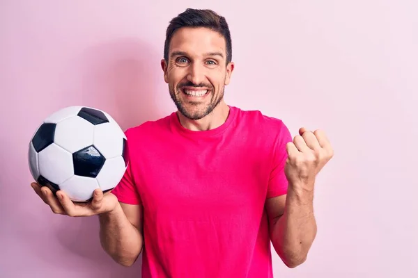 若いですハンサムなプレーヤー男遊びサッカー保持ボール上の隔離されたピンクの背景悲鳴誇りに思って 勝利と成功を祝う非常に興奮して上げ腕 — ストック写真