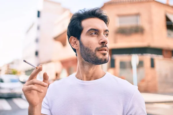 Ung Latinamerikansk Man Med Allvarligt Uttryck Som Håller Cigarett Gående — Stockfoto