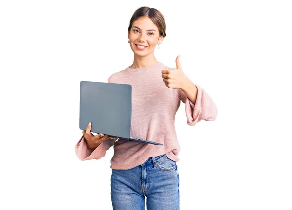 아름다운 금발의 여성이 컴퓨터 랩탑으로 행복하고 긍정적 미소를 있습니다 엄지손가락은 — 스톡 사진