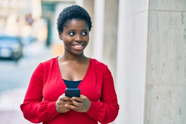 在城市里 年轻的非洲裔美国女人高兴地使用智能手机 — 图库照片