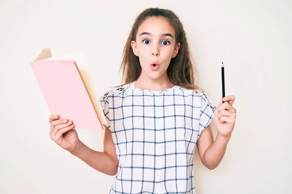 Menina Hispânica Bonito Segurando Livro Lápis Assustado Espantado Com Boca — Fotografia de Stock