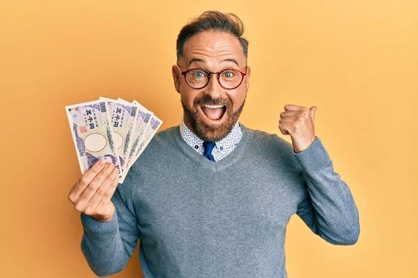 5000円の紙幣を持っているハンサムな中年の男性口を開けて幸せな笑顔側に親指を指す — ストック写真