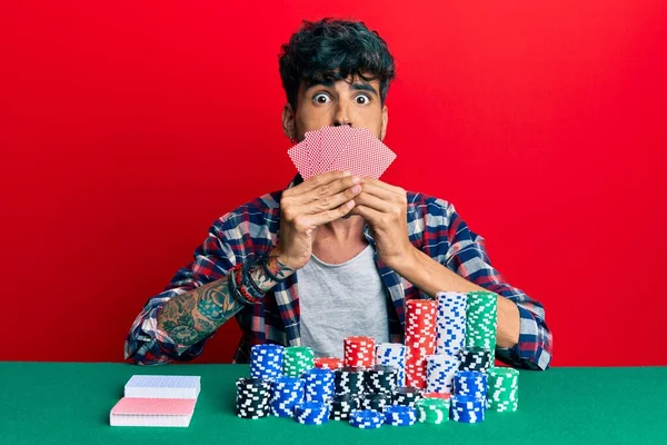 Jovem Hispânico Jogando Poker Cobrindo Rosto Com Cartões Soprando Bochechas — Fotografia de Stock
