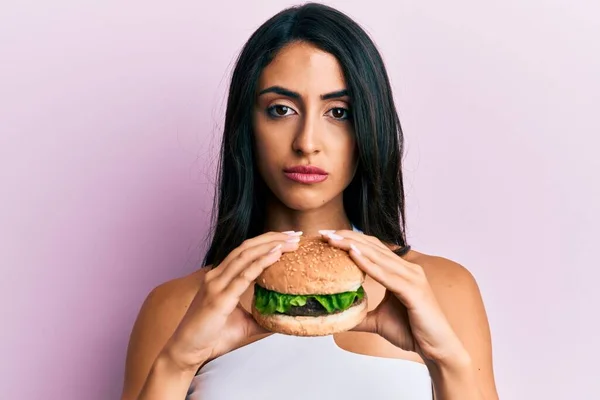 Όμορφη Ισπανόφωνη Γυναίκα Τρώει Ένα Νόστιμο Κλασικό Burger Χαλαρή Σοβαρή — Φωτογραφία Αρχείου