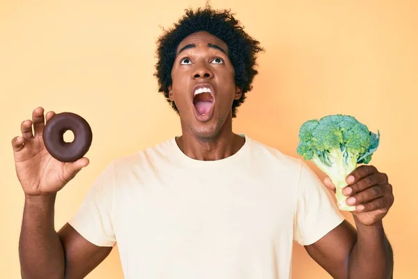 Hombre Afroamericano Guapo Con Cabello Afro Sosteniendo Brócoli Donut Chocolate —  Fotos de Stock