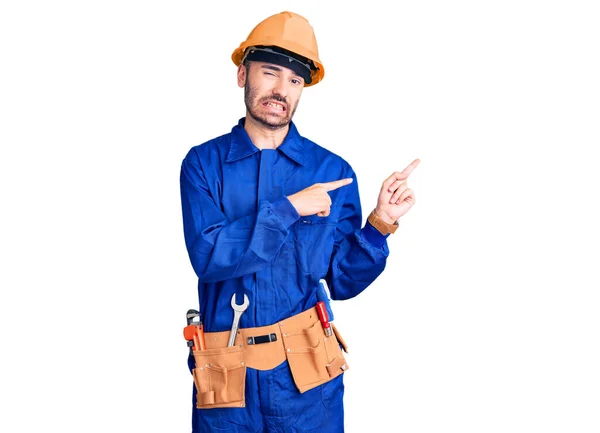 Young Hispanic Man Wearing Worker Uniform Pointing Aside Worried Nervous — Stock Photo, Image