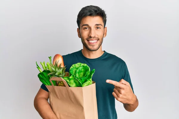 Joven Hombre Guapo Sosteniendo Bolsa Papel Con Pan Comestibles Sonriendo —  Fotos de Stock