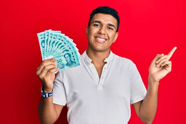 Joven Árabe Sosteniendo Billetes Chinos Yuan Sonriendo Feliz Señalando Con — Foto de Stock