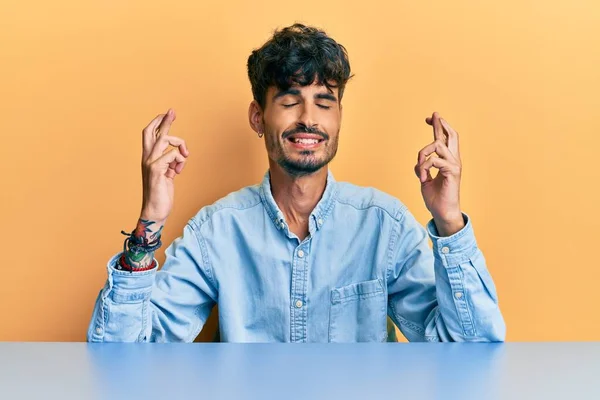 Ung Latinamerikansk Man Klädd Avslappnade Kläder Sittande Bordet Gestikulerande Finger — Stockfoto