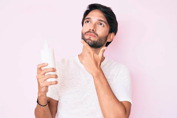 Beau Hispanique Homme Tenant Crème Hydratante Cosmétique Visage Visage Sérieux — Photo