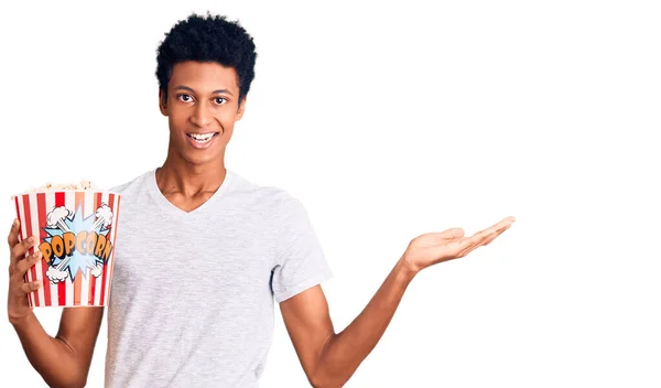 Joven Afroamericano Sosteniendo Palomitas Maíz Celebrando Victoria Con Sonrisa Feliz — Foto de Stock